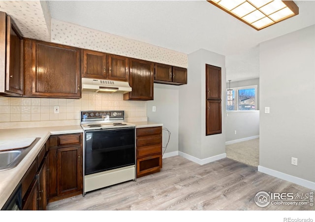 kitchen featuring range with electric stovetop, backsplash, and light wood-type flooring