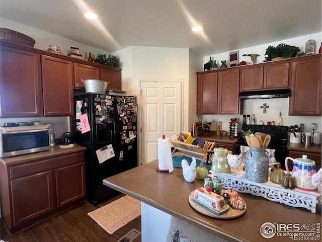 kitchen with black appliances and dark hardwood / wood-style floors