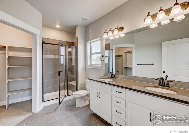 bathroom featuring tile patterned flooring, vanity, toilet, and an enclosed shower