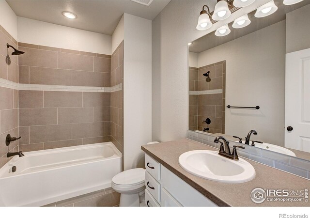 full bathroom featuring toilet, vanity, and tiled shower / bath