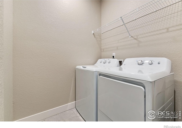 laundry area with washing machine and dryer and light tile patterned floors