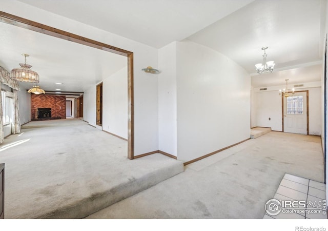 interior space with a wealth of natural light, a fireplace, light colored carpet, and an inviting chandelier