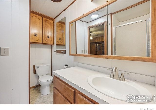 bathroom with wooden walls, a shower with door, vanity, and toilet