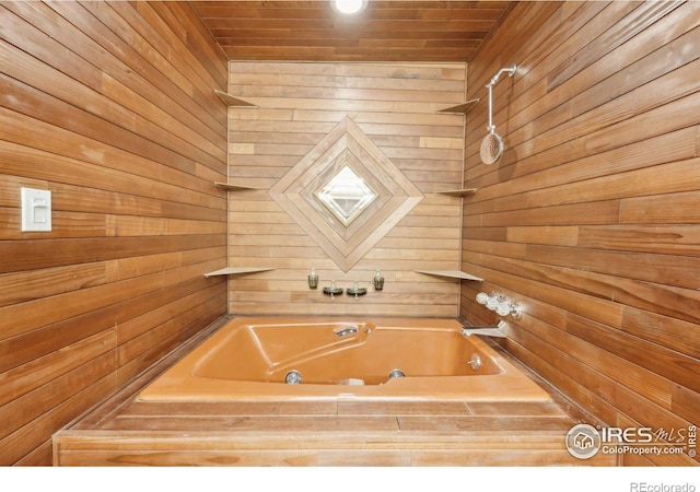 bathroom featuring a washtub, wood walls, and wooden ceiling