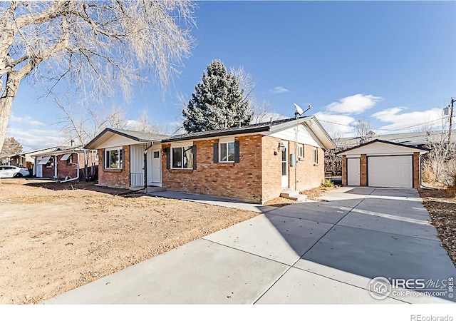 ranch-style home with concrete driveway, brick siding, an outdoor structure, and a detached garage