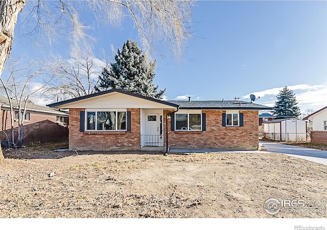 single story home with fence, concrete driveway, and brick siding