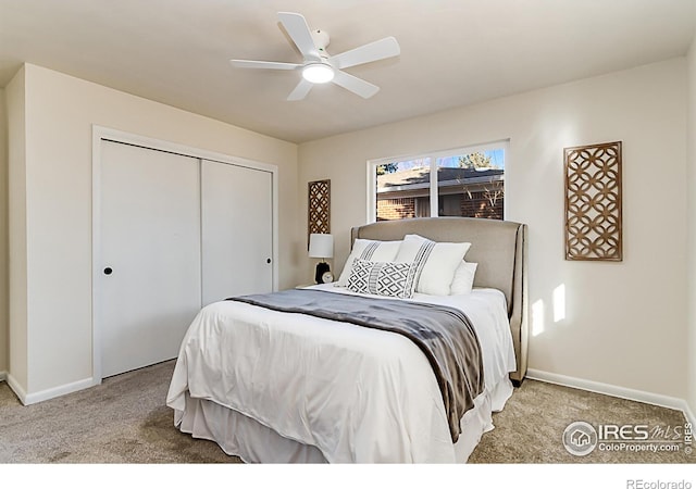 bedroom featuring baseboards, ceiling fan, a closet, and light colored carpet