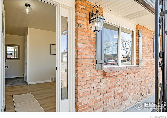 property entrance with brick siding and visible vents