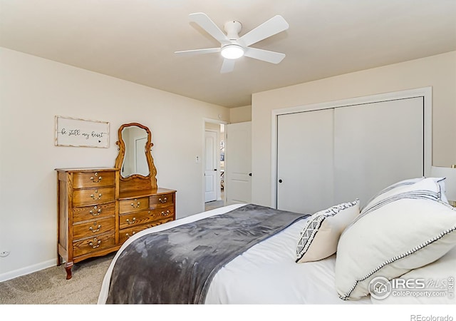 bedroom featuring a closet, light colored carpet, ceiling fan, and baseboards