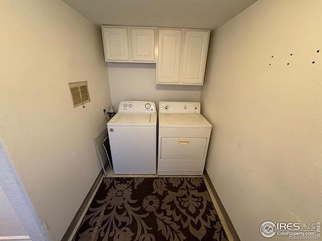 laundry room featuring washer and clothes dryer and cabinets