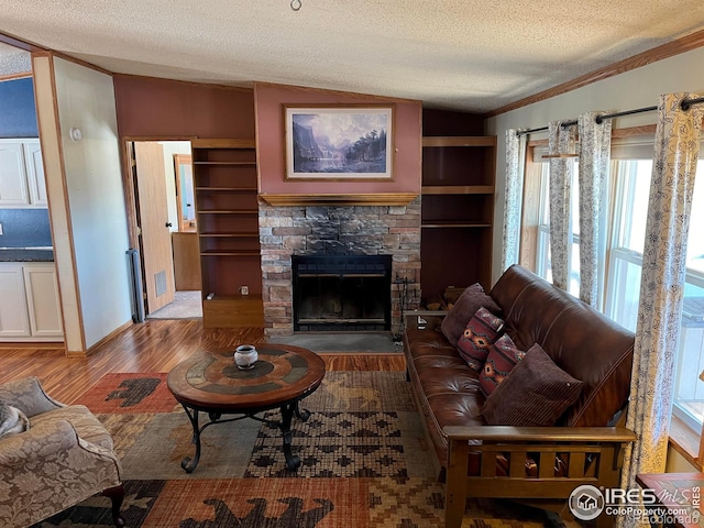 living room featuring a textured ceiling, a stone fireplace, vaulted ceiling, and hardwood / wood-style flooring