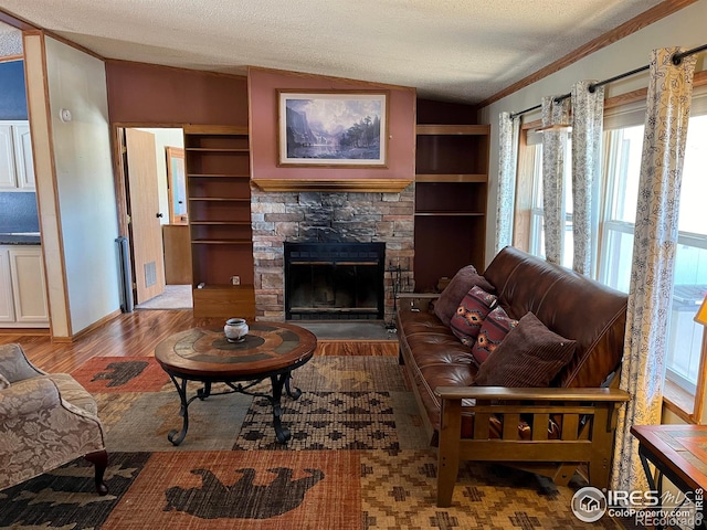 living room featuring a stone fireplace, crown molding, a textured ceiling, lofted ceiling, and light wood-type flooring