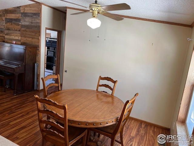 dining area featuring lofted ceiling, crown molding, dark hardwood / wood-style floors, ceiling fan, and a textured ceiling