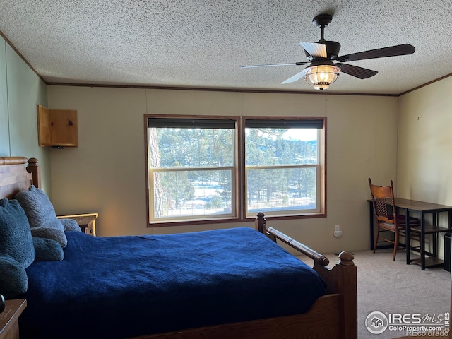 carpeted bedroom featuring ceiling fan, ornamental molding, and a textured ceiling