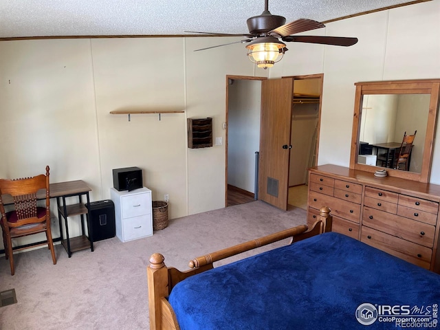 bedroom featuring a textured ceiling, ceiling fan, light colored carpet, and vaulted ceiling