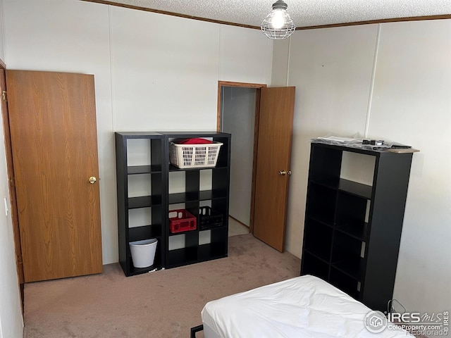 bedroom with a textured ceiling and light colored carpet