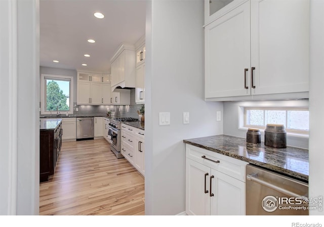 kitchen featuring a wealth of natural light, light hardwood / wood-style floors, white cabinetry, and appliances with stainless steel finishes