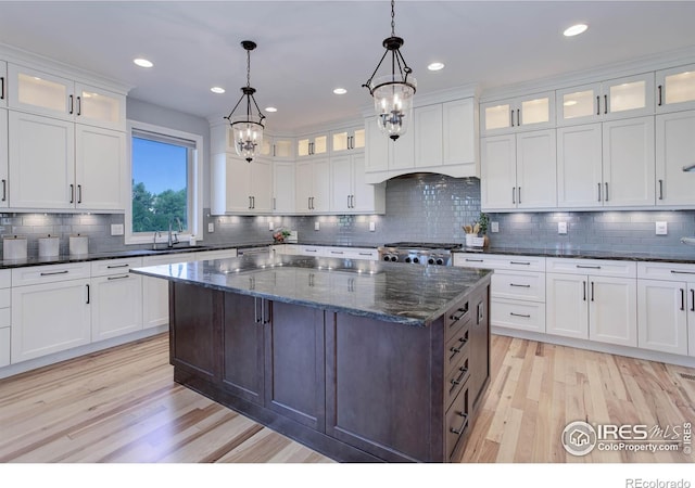 kitchen with white cabinets, a kitchen island, and light hardwood / wood-style floors