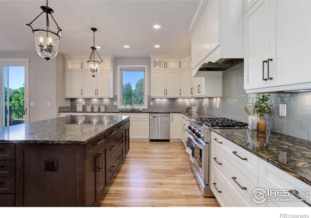 kitchen featuring white cabinets, a center island, stainless steel appliances, and light hardwood / wood-style flooring