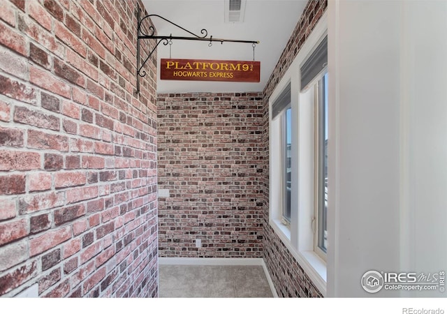 interior space with carpet and brick wall