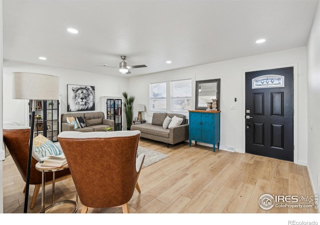 living room featuring light hardwood / wood-style flooring and ceiling fan