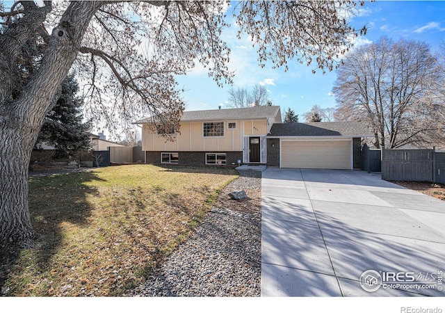 raised ranch featuring a front lawn and a garage