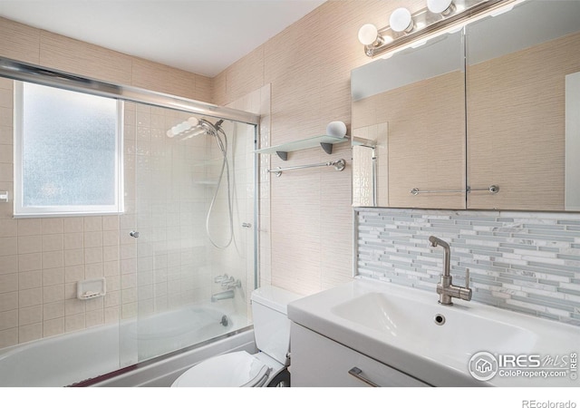 full bathroom with toilet, shower / bath combination with glass door, decorative backsplash, vanity, and tile walls