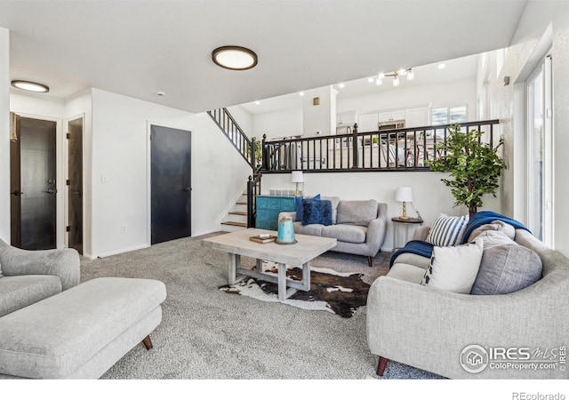 living area featuring carpet floors and stairs