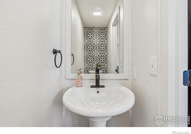 bathroom with a sink and a textured wall