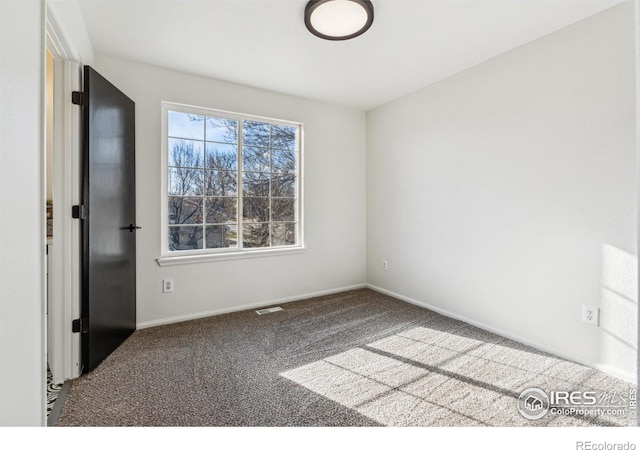 spare room featuring baseboards and carpet flooring