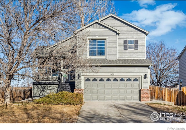 view of front of property with a garage, brick siding, driveway, and fence