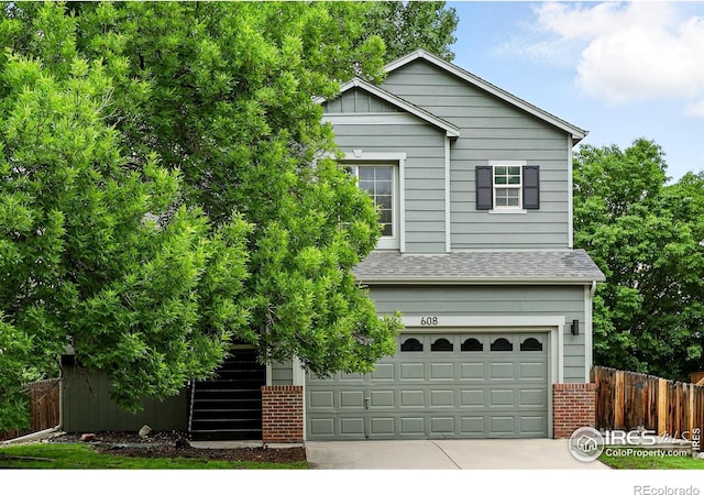 608 Bluegrass Dr, Longmont, CO 80503 - view of front of property with brick siding, concrete driveway, a garage, roof with shingles, and stairs