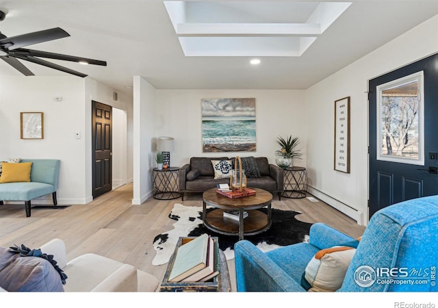 living room featuring a baseboard radiator, light hardwood / wood-style flooring, and ceiling fan