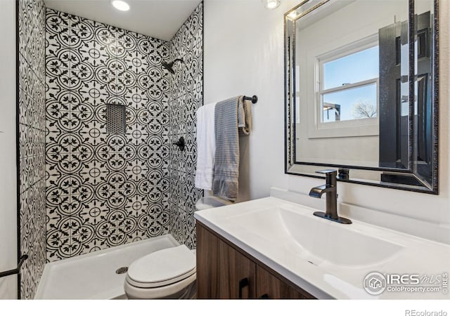 bathroom featuring a shower, vanity, and toilet