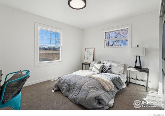 bedroom featuring carpet flooring and a baseboard heating unit