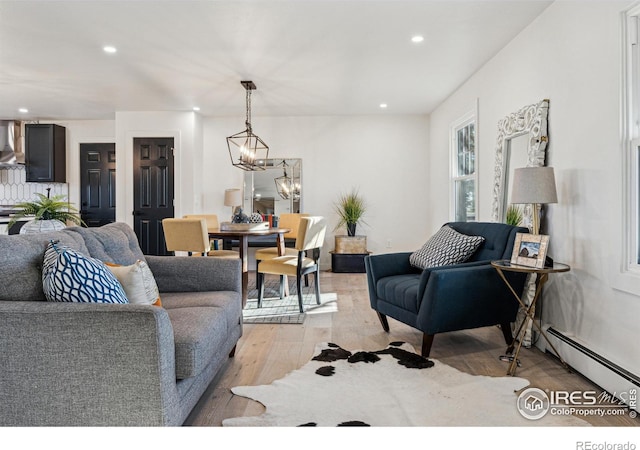 living room featuring a notable chandelier, light hardwood / wood-style flooring, and a baseboard radiator