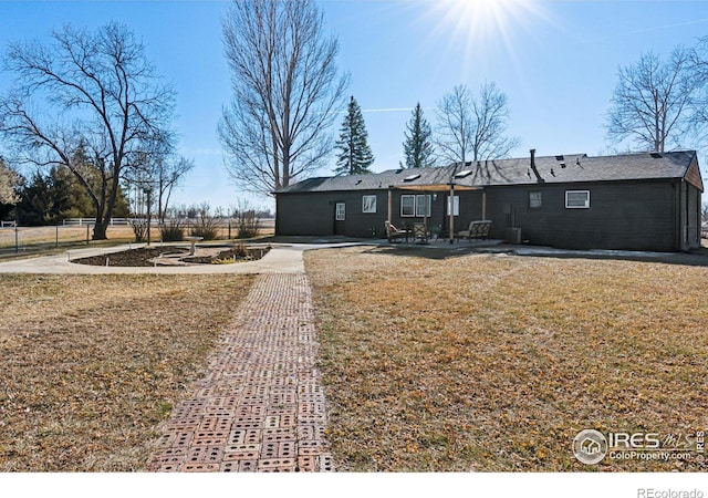 ranch-style home featuring a front lawn and a patio