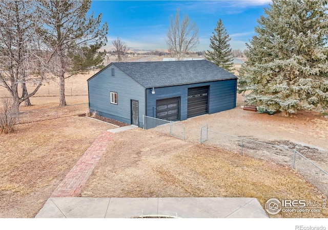 detached garage featuring a gate and fence