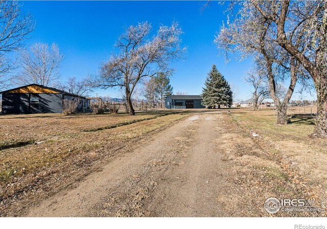 view of front of house featuring a rural view and dirt driveway