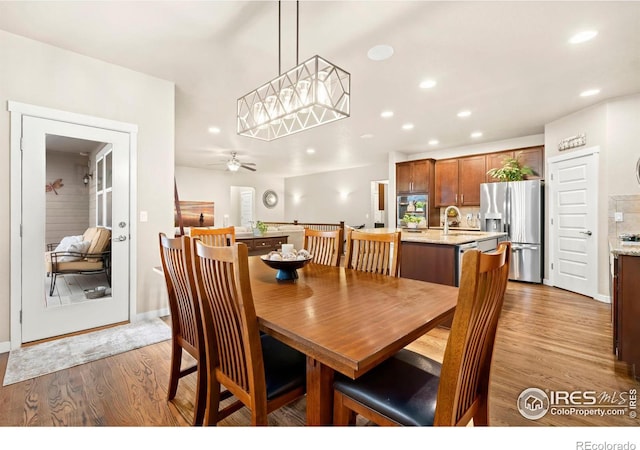 dining space with light hardwood / wood-style flooring, ceiling fan, and sink