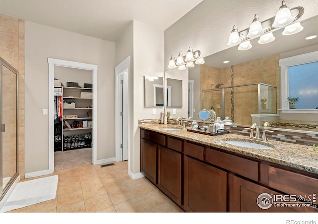 bathroom featuring tile patterned flooring, vanity, and an enclosed shower