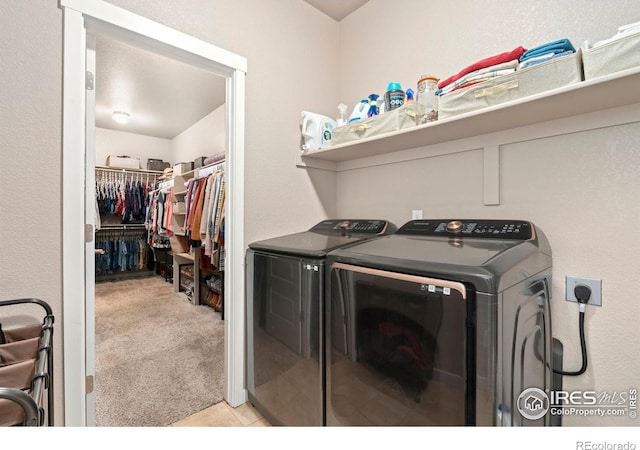 laundry area with washer and clothes dryer and light carpet