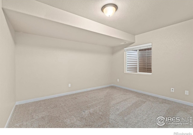 unfurnished room with carpet floors and a textured ceiling