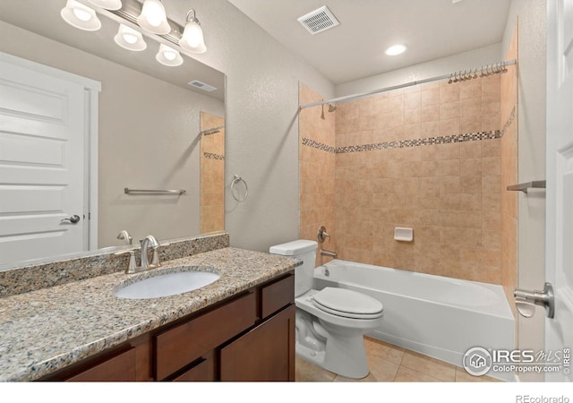 full bathroom featuring tile patterned floors, vanity, tiled shower / bath combo, and toilet