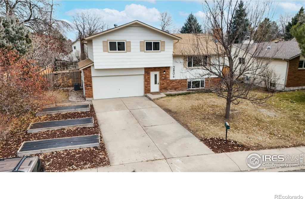 tri-level home with central AC unit and a garage