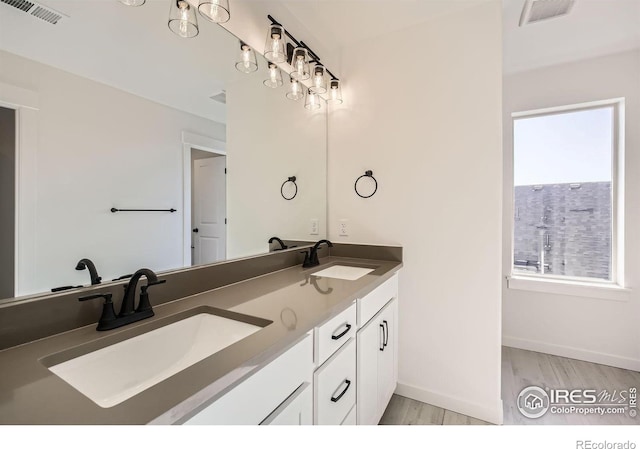 full bath featuring wood finished floors, a sink, and visible vents