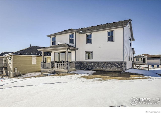 view of front of home featuring covered porch and stone siding