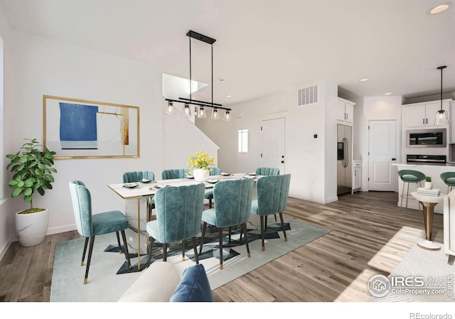 dining room featuring baseboards, visible vents, wood finished floors, and recessed lighting