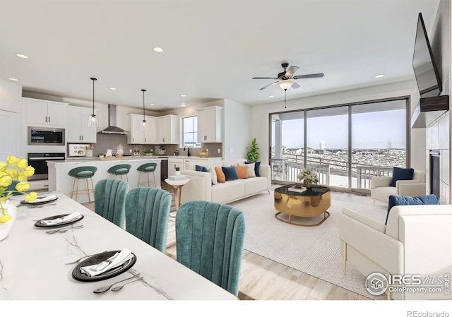 living area featuring light wood finished floors, recessed lighting, a wealth of natural light, and a ceiling fan