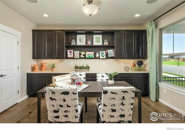 kitchen with hardwood / wood-style floors, a center island, dark brown cabinetry, and a breakfast bar area